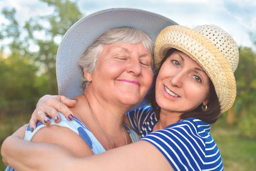 Happy daughter embracing her smiling mother.