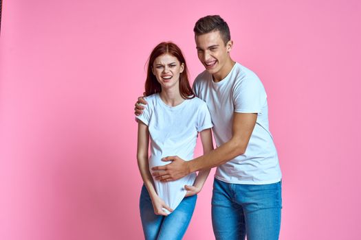 pregnant mom and happy father on pink background Young family waiting for baby. High quality photo