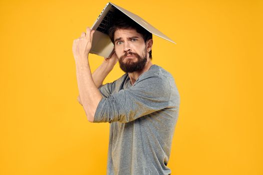 man with laptop wireless technology internet lifestyle work yellow isolated background. High quality photo