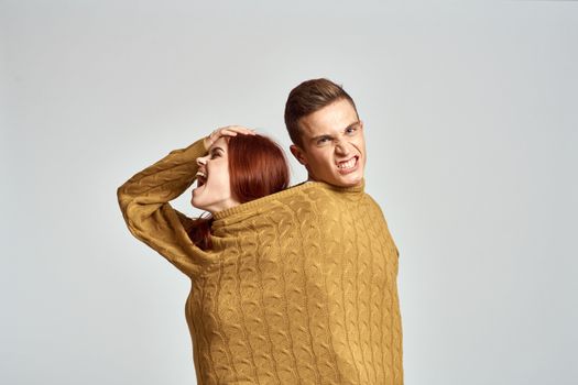 couple in yellow sweater posing against light background cropped view. High quality photo