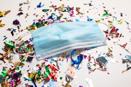 Used facemask droped on flor with confetti after celebration new year 2021 party background stock image