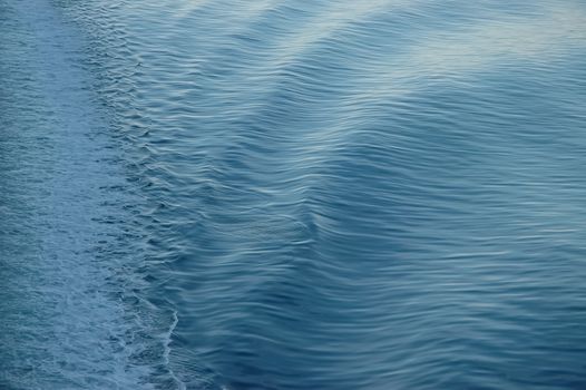 white backwash of a ferry crossing blue ocean