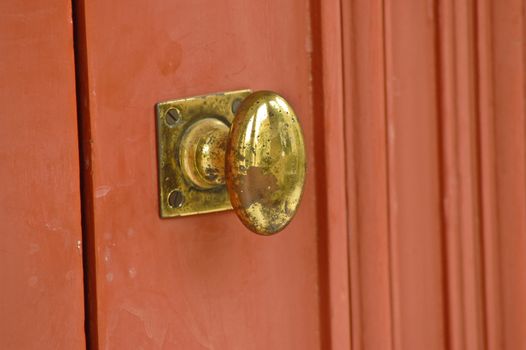 Golden vintage asian door knob on red teak door