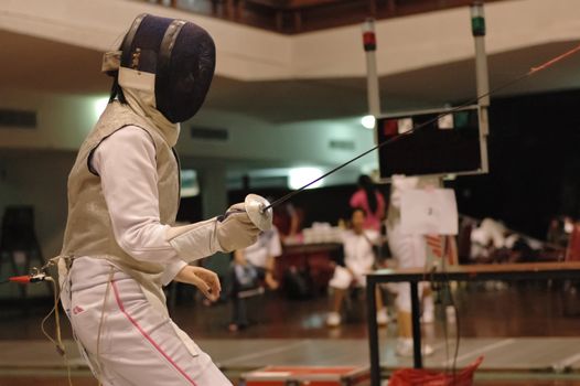 Foil fencing sport fighter on guard and ready to fight in the competition