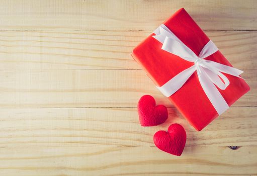 Gift box white bow ribbon and heart on wood table background top view, february of valentines day in concept.