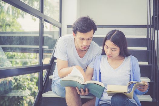 Couple asian handsome man and beautiful woman reading book and smile at home, boyfriend and girlfriend with activities together for leisure, education concept.