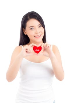 Portrait of beautiful asian young woman holding red heart shape pillow and smile isolated on white background, valentines day, holiday concept.