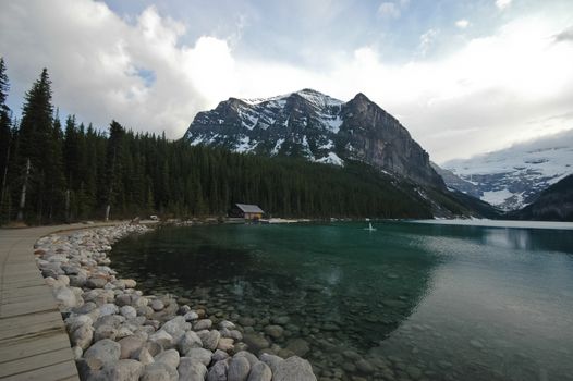 walk way near pristine lake and snow mountain