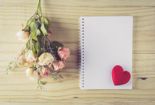 Vintage flower bouquet on wooden table with top view, romantic with love heart on paper for text copy sapce, valentine holiday concept.