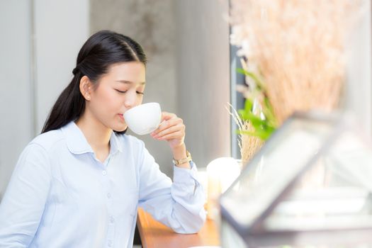 Beautiful  young asian woman drinking coffee and smile in the morning at cafe, girl sitting in coffee shop for breakfast and leisure during free time.