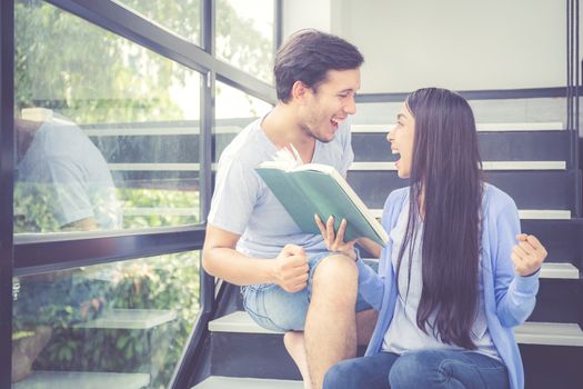 Couple asian handsome man and beautiful woman reading book and glad at home, boyfriend and girlfriend with activities together for leisure, education success concept.
