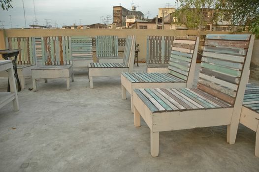 wooden beach chairs on a roof top of bangkok building