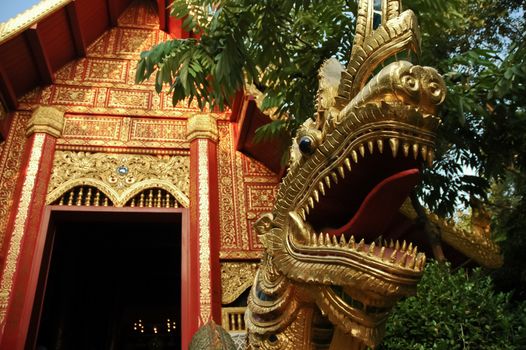 Golden naga Thai style dragon and majestic gold temple in Northern Thailand