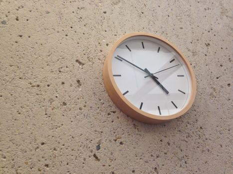 Simple classical analog wall clock on stone wall