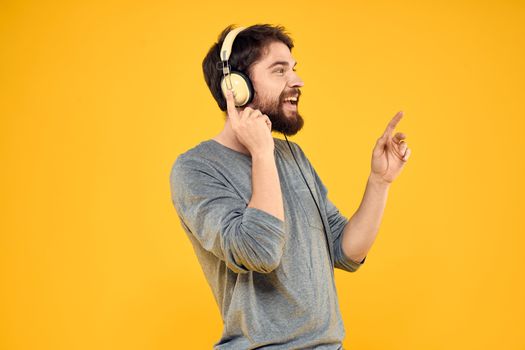 Man with headphones music lifestyle lifestyle technology yellow background. High quality photo