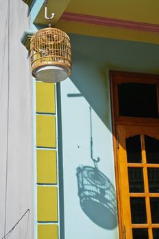 Asian bird in brown wooden cage in Vietnam