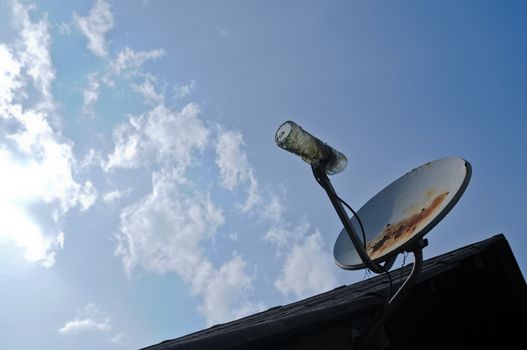 Rustic old parabolic satellite station and blue sky