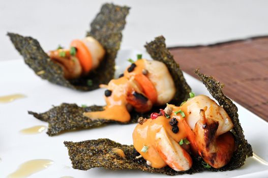 grilled scallops with sour sauce on crispy seaweed