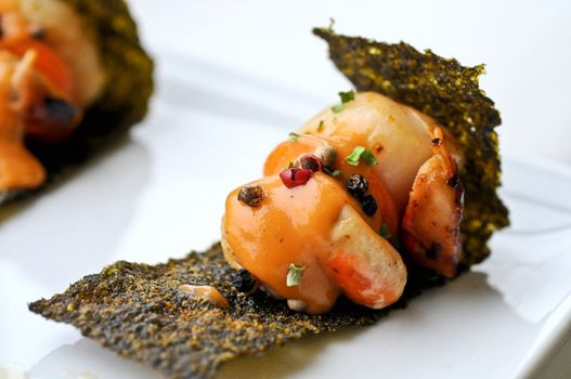 Delicacy grilled scallops with sour sauce on crispy seaweed