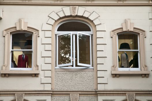 Windows of clothes shop showing red and white suits in Italy