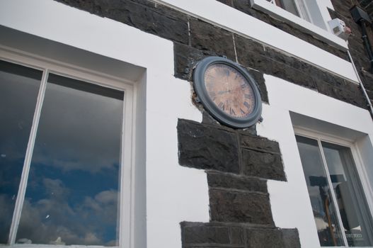Antique public clock on the building wall in Europe