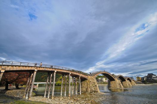 Original ancient stone arc bridge on a calm river in Japan