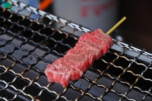 Marbled martinated fresh Hida Japanese beef skewer grilled on charcoal cooker