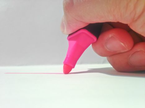hand holding pink highlighter pen