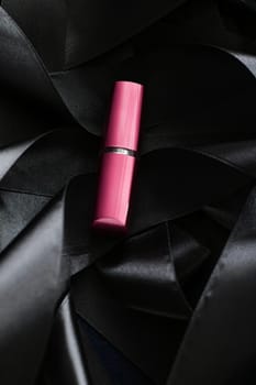 Pink lipstick on black silk background, luxury make-up and beauty cosmetics