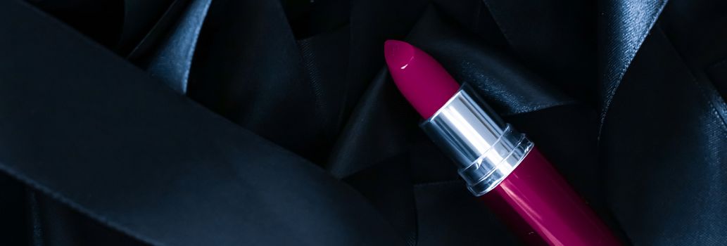 Purple lipstick on black silk background, luxury make-up and beauty cosmetics