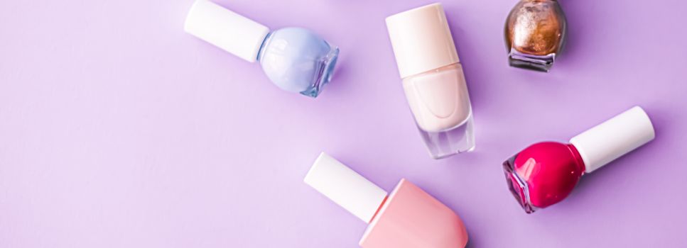 Nail polish bottles on purple background, beauty branding