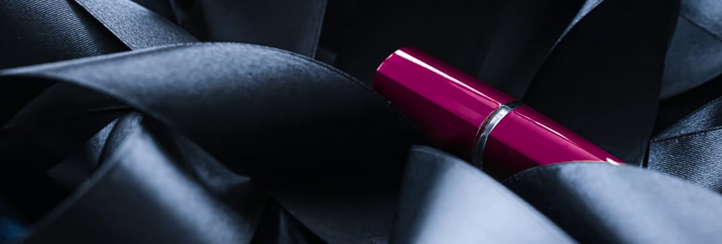 Purple lipstick on black silk background, luxury make-up and beauty cosmetics