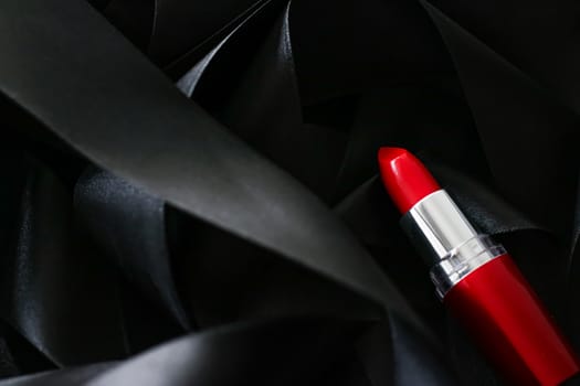 Red lipstick on black silk background, luxury make-up and beauty cosmetics