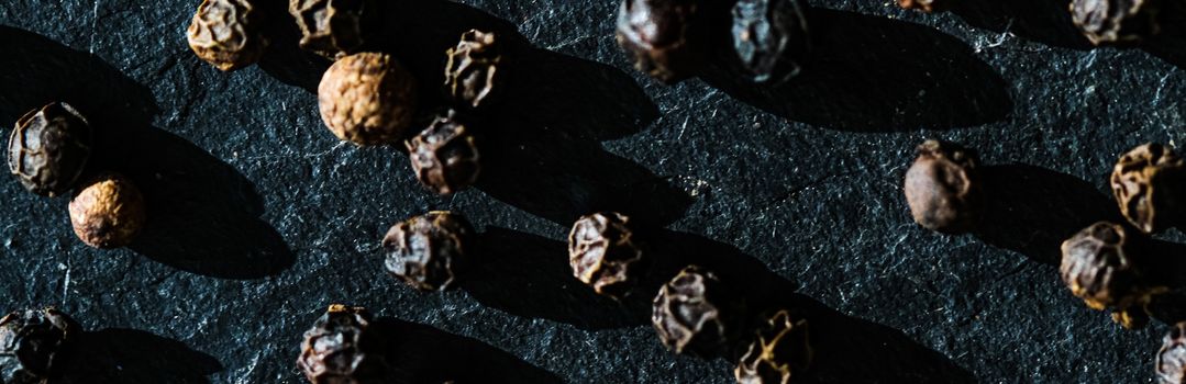 Black pepper closeup on luxury stone background as flat lay, dry food spices and recipe ingredients