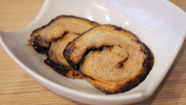 Chashu pork slide 2 pieces for top up on the traditional tonkotsu japanese ramen noodle dish.