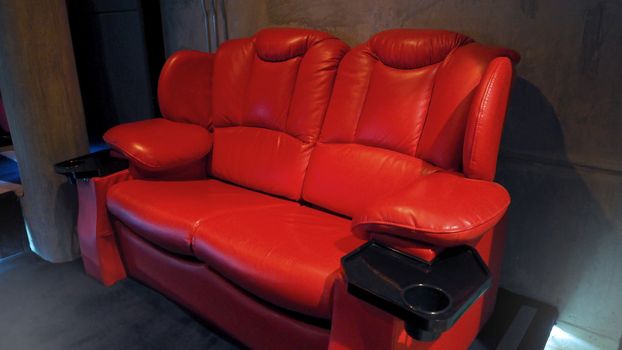 Red color leather movie theater cinema seat chairs which small and old dirty and very bad stingy smell.