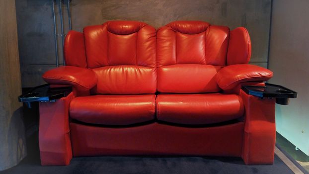 Red color leather movie theater cinema seat chairs which small and old dirty and very bad stingy smell.