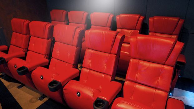 Red color leather movie theater cinema seat chairs which small and old dirty and very bad stingy smell.