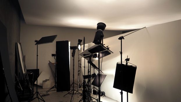 Studio lighting setup for photo shooting production with many equipment such as softbox, backdrop paper, white reflect foam and many more.