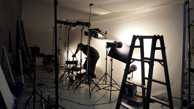 Studio lighting setup for photo shooting production with many equipment such as softbox, backdrop paper, white reflect foam and many more.