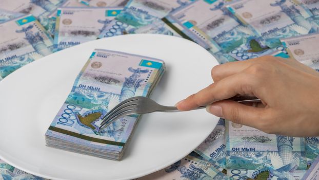 Divide the budget. Kazakhstan banks and loans in tenge.A lot of Kazakhstan tenge in a circle on the table. The national currency of Kazakhstan. Salary in tenge. Grocery basket, budget savings.
