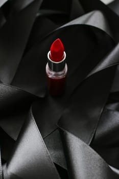 Red lipstick on black silk background, luxury make-up and beauty cosmetics