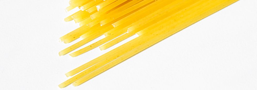 Uncooked whole grain spaghetti closeup, italian pasta as organic food ingredient, macro product and cook book recipes