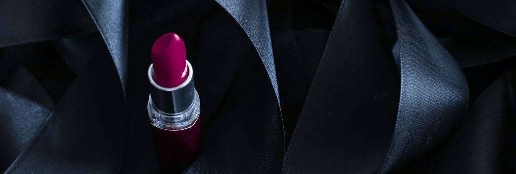 Purple lipstick on black silk background, luxury make-up and beauty cosmetics