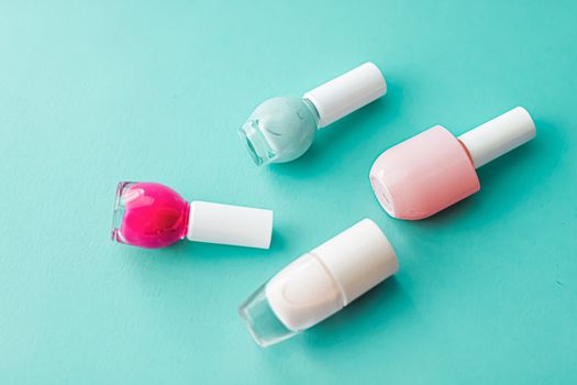 Nail polish bottles on green background, beauty branding