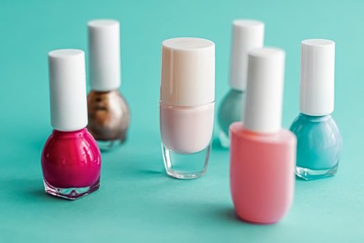 Nail polish bottles on green background, beauty branding