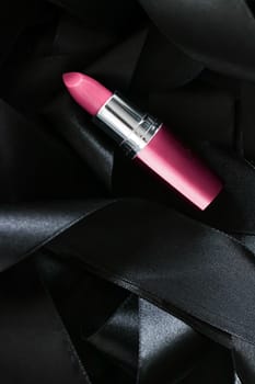 Pink lipstick on black silk background, luxury make-up and beauty cosmetics