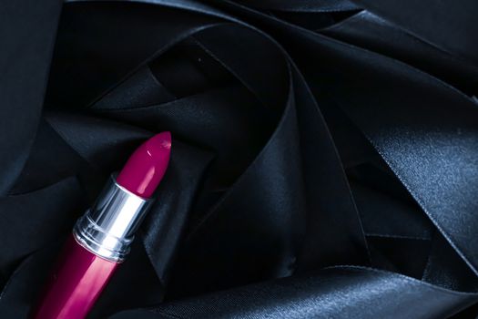 Purple lipstick on black silk background, luxury make-up and beauty cosmetics