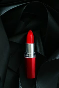 Red lipstick on black silk background, luxury make-up and beauty cosmetics