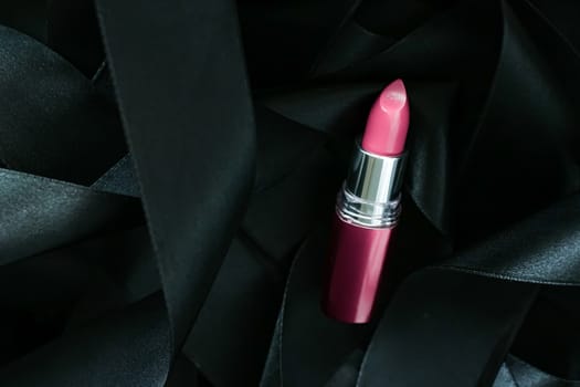 Pink lipstick on black silk background, luxury make-up and beauty cosmetics